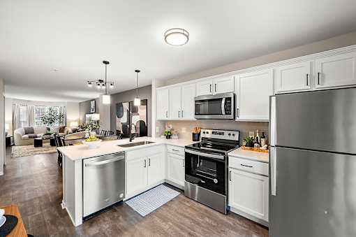 A modern kitchen with stainless steel appliances and white cabinets.