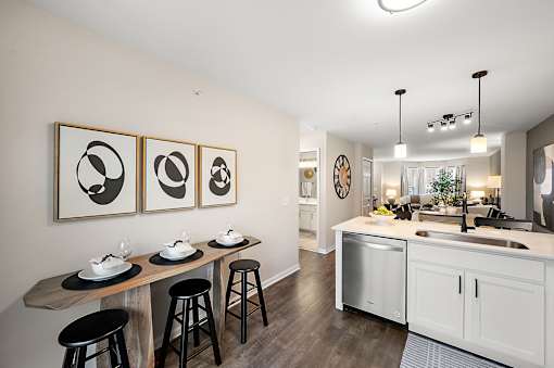 A kitchen with a white counter and black stools.