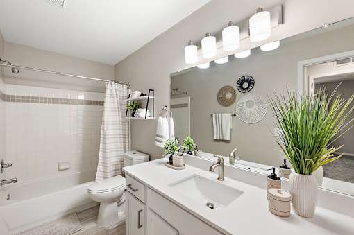 A bathroom with a white tub, sink, and toilet.