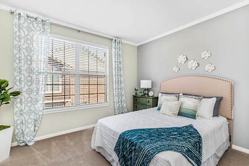 A bedroom with a large bed and a window with curtains at Park West, Canton, 48187