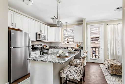 A kitchen with a refrigerator, microwave, oven, and sink at Park West, Canton, 48187
