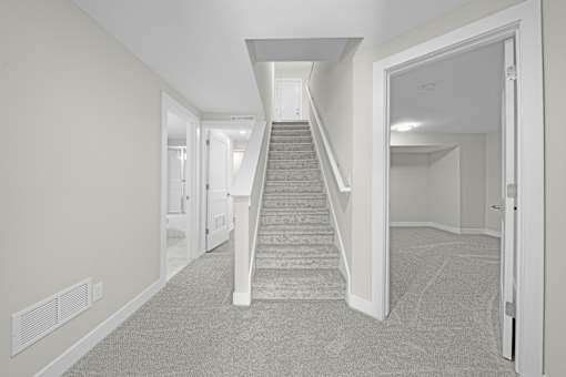 A hallway with a staircase leading to the second floor at Amberly Apartments, West Bloomfield, 48322