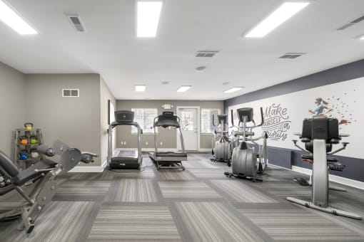 Gym with cardio machines and weights at Amberly Apartments, West Bloomfield, 48322