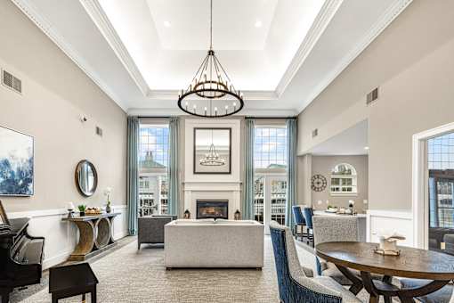 A large, well-lit living room with a fireplace and a dining table.