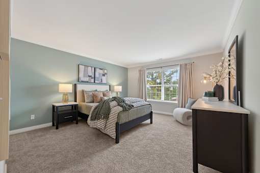 A bedroom with a bed, nightstand, and a lamp.