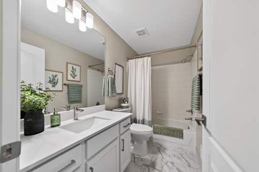 A bathroom with a white sink and a white toilet.