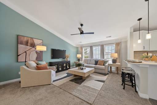 A living room with a couch, a chair, a coffee table, and a painting on the wall.