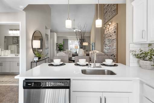 A modern kitchen with a large island and a stainless steel dishwasher.