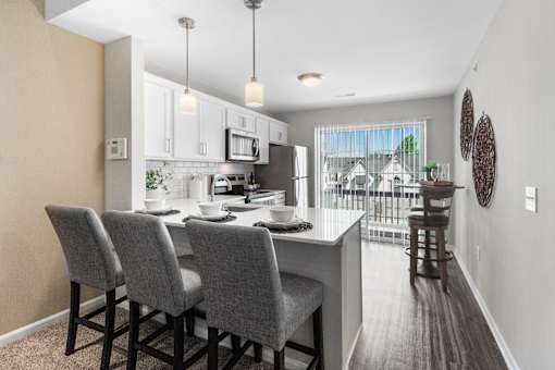 A kitchen with a table and chairs.