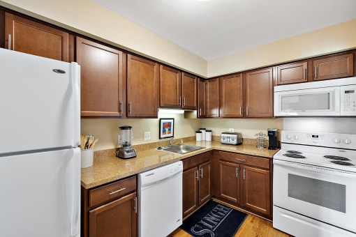 a kitchen with white appliances and brown cabinets