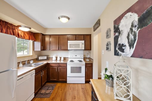 a kitchen with white appliances and wooden cabinets  at Northridge, Rochester Hills, MI, 48307