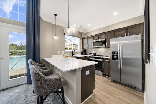 A modern kitchen with a large island and stainless steel appliances.
