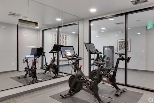 A gym with exercise bikes and a mirror.