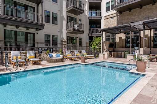 A large swimming pool in front of apartment buildings.