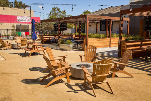 a patio with wooden chairs and a fire pit at AVE Santa Clara, Santa Clara