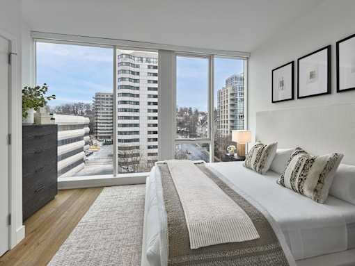 A bedroom with a large bed and a view of the city.