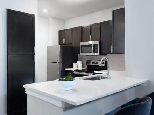 a kitchen with white countertops and black cabinets