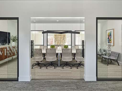A conference room with glass walls and a carpeted floor.