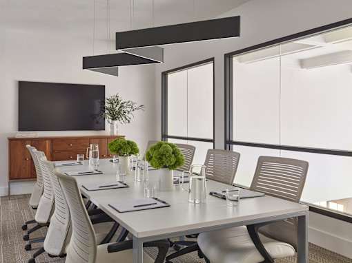 A conference room with a long table and chairs.