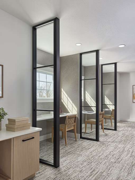 A room with a desk, chair, and a large mirror.
