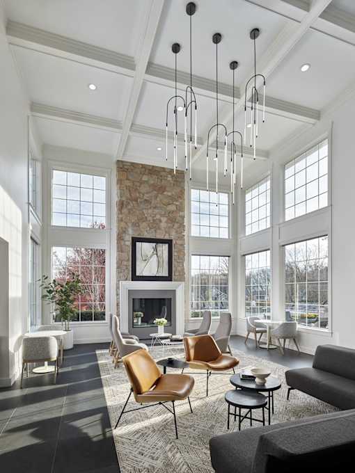 A living room with a stone fireplace and a large window.