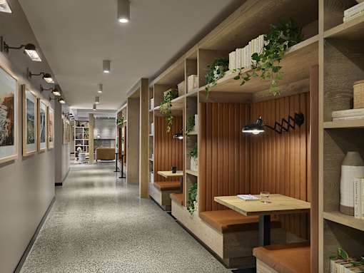 A long hallway with tables and shelves on the side.