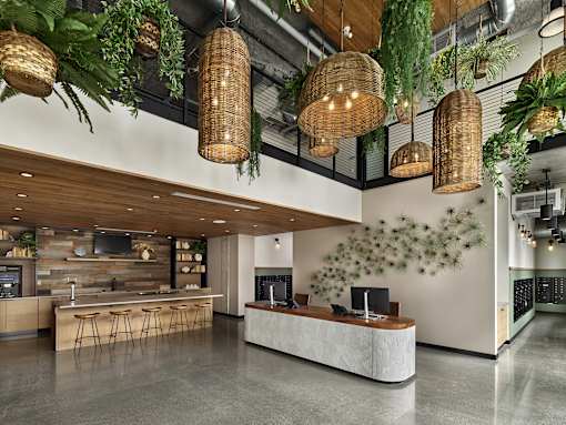 A modern bar area with a white counter and wooden bar stools.