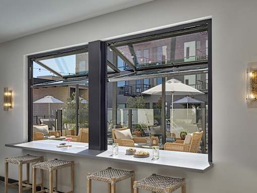 A modern bar with a view of the outdoors through large windows.