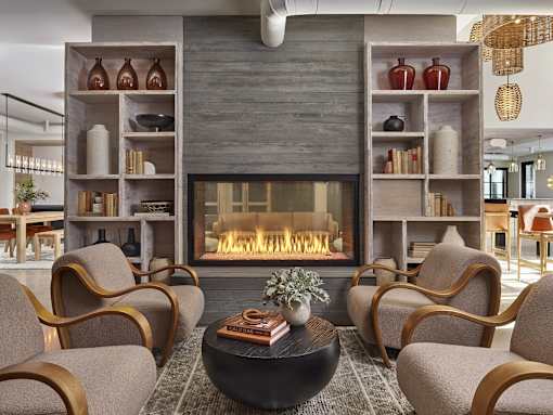 A living room with a fireplace and chairs.