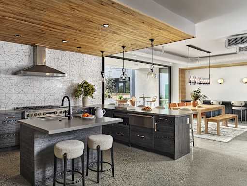 A modern kitchen with a wooden ceiling and a marble countertop.