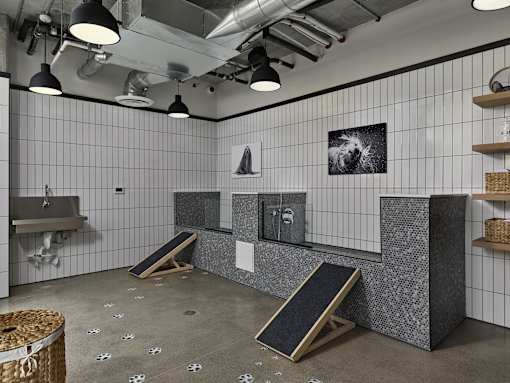 A room with a grey floor and white tiled walls.