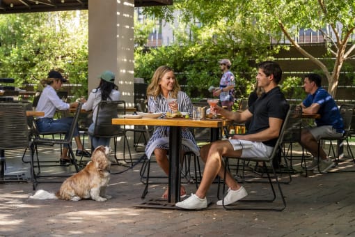 a group of people sitting at a patio table with a dog at AVE Phoenix Terra, Arizona, 85003