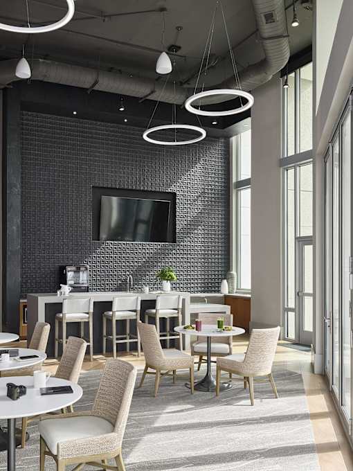 A modern dining room with a large table and chairs.