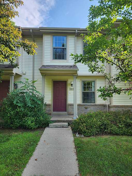 A house with a red door and a window with a curtain.