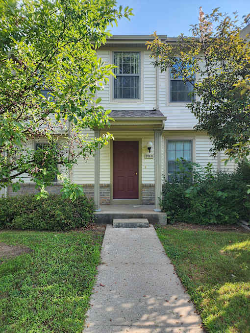 A white building with a red door and windows.
