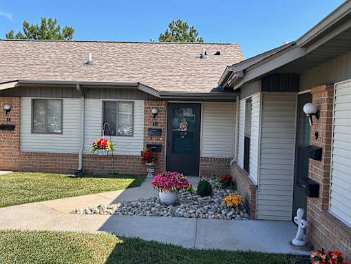 a home with a green door and flowers in the front yard