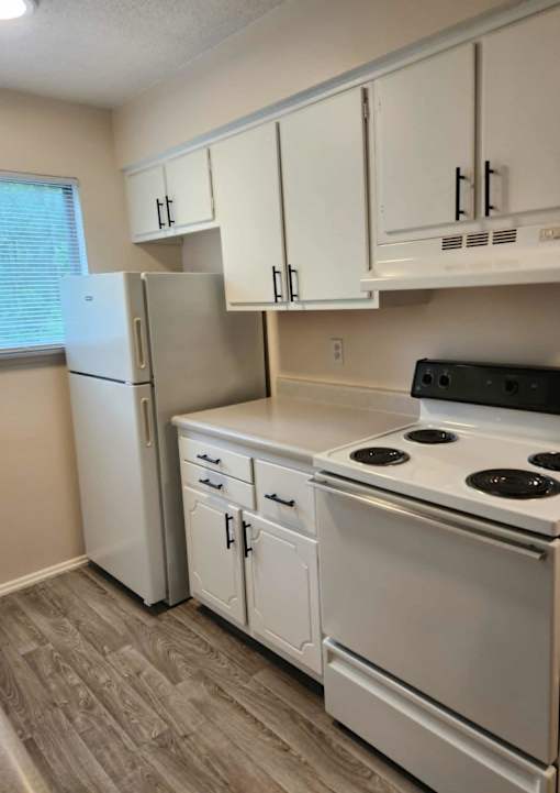 A kitchen with white appliances and cabinets.