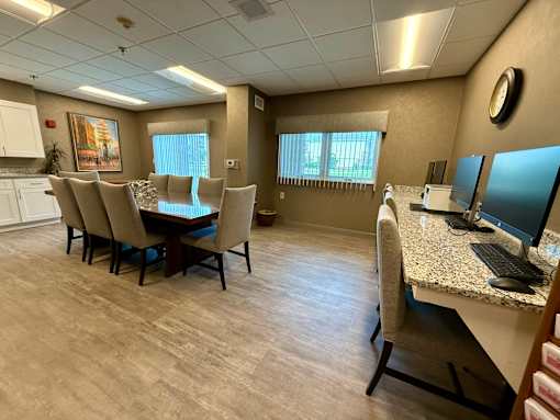 A conference room with a table, chairs, and a computer.