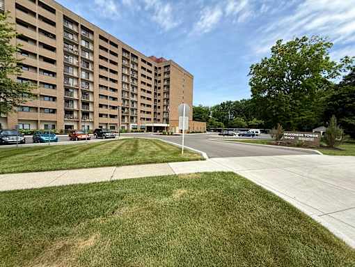 A large apartment complex with a grassy area in front.