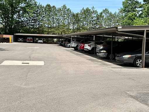A parking lot with cars parked under a shelter.