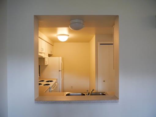 A small kitchen with a refrigerator, stove, and sink.