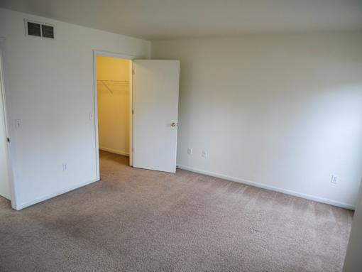 A room with a carpeted floor and a closed door.