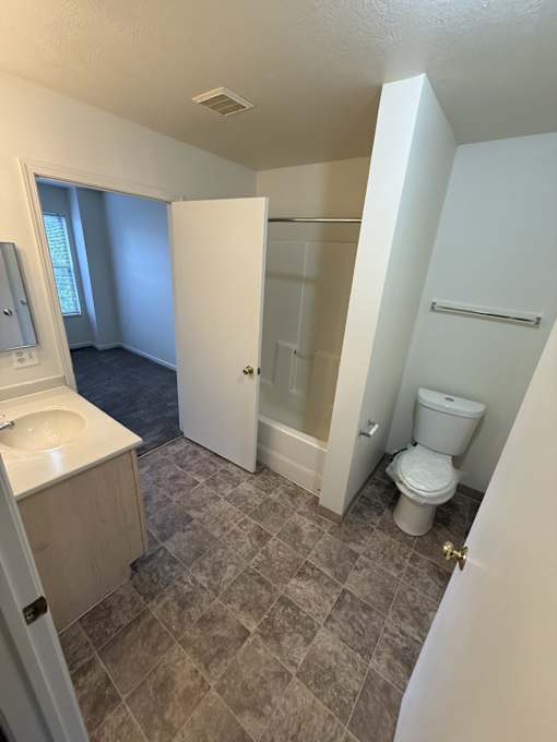 A bathroom with a toilet, sink, and shower.