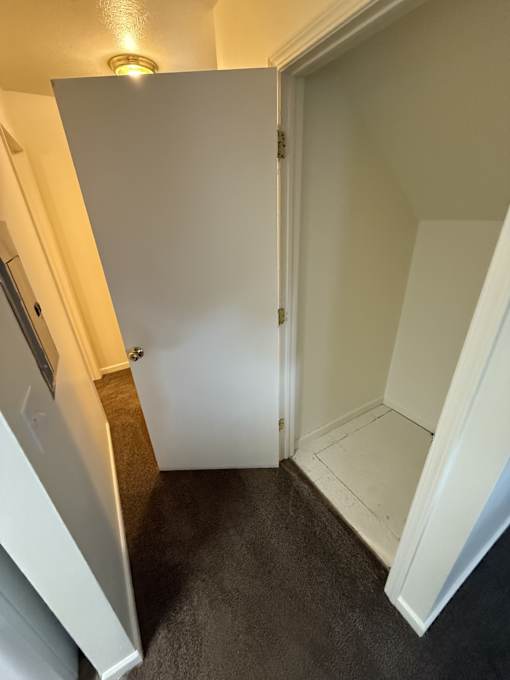 A white door is open to a small room.