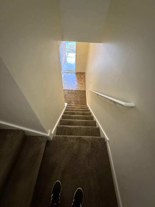 A person is standing on a staircase looking at a doorway.