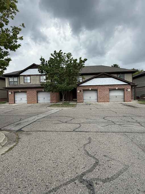 A large, two-story house with a garage on the ground floor.