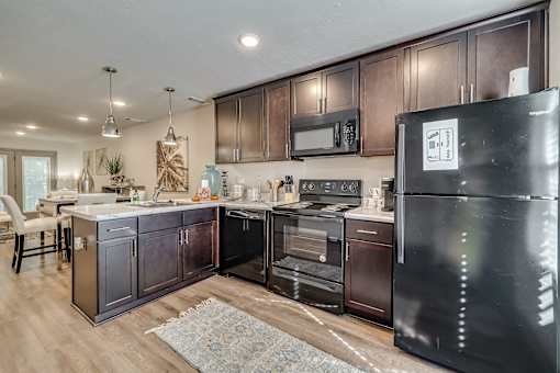 Kitchen with cherry wood cabinets and black appliances at Forest Hills Racquet Club, Augusta