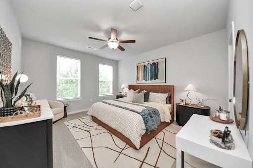 A bedroom with a large bed and a ceiling fan.