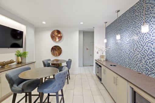 A lounge with a table and chairs and a kitchen with a counter