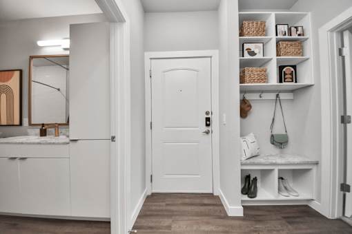 A white door is in a hallway with a shelf above it.